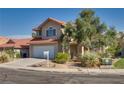 Inviting two-story home with a red tile roof, a two-car garage, and desert landscaping at 8771 Martinique Bay Ln, Las Vegas, NV 89147