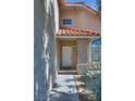 Welcoming front entrance with a white door and a red tile roof overhang, offering a glimpse of the exterior at 8771 Martinique Bay Ln, Las Vegas, NV 89147