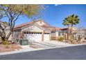 Charming single-story home featuring a three-car garage, desert landscaping, and tile roof at 8894 Don Horton Ave, Las Vegas, NV 89178