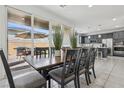 Open dining area features a modern table, seating for six, and sliding glass doors to the patio at 160 Lilt Ave, Henderson, NV 89011