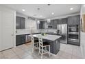 Bright kitchen boasts gray cabinets, stainless appliances, and stylish pendant lighting over the island at 160 Lilt Ave, Henderson, NV 89011