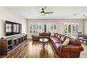 Spacious living room with wood floors, ceiling fan, and large windows at 2104 Willow Wren Dr, North Las Vegas, NV 89084