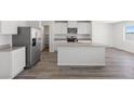 Modern kitchen featuring stainless steel appliances, gray countertops, and vinyl plank flooring, perfect for culinary enthusiasts at 2606 Lily Point St, Las Vegas, NV 89156
