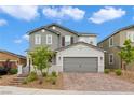 Charming two-story home featuring a gray exterior, brick driveway, and well-maintained landscaping at 2616 Tolmezzo St, Henderson, NV 89044