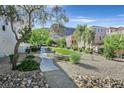 Serene community grounds with lush landscaping and walking paths; mountain views in background at 3457 Abilene Gold Ct, Las Vegas, NV 89129