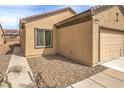Close up view of a house with a two-car garage and desert landscaping in the front yard at 3520 Kittiwake Rd, North Las Vegas, NV 89084