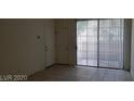 Living room featuring sliding doors to patio with vertical blinds and tiled floors at 5158 S Jones Blvd # 107, Las Vegas, NV 89118