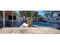 View of backyard with swimming pool, dining area, and lush landscaping at 5318 Palmyra Ave, Las Vegas, NV 89146