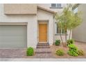Close-up of the home's front door with brick entry and landscaped bushes at 6952 Crimson Shadow St, North Las Vegas, NV 89086