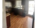Bright kitchen featuring wooden floors and sliding glass doors to the backyard at 7098 Forest Vista St, Las Vegas, NV 89147