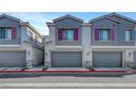A row of modern townhomes showing garages, tasteful exterior paint, stone accents, and a red fire lane curb on the street at 7204 N Decatur Blvd, North Las Vegas, NV 89131