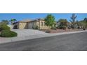 Desert home boasts a long driveway leading to a three car garage, complemented by desert landscaping at 8370 Unicorn St, Las Vegas, NV 89131