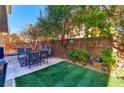 Outdoor patio area with artificial grass and mature landscaping at 9692 Waukegan Ave, Las Vegas, NV 89148