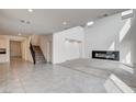 Bright open living room with modern fireplace, staircase and easy access to kitchen at 9993 Birch Knoll Ave, Las Vegas, NV 89166