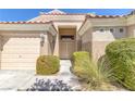 Welcoming front entrance with double doors, convenient attached garage and desert landscaping at , Las Vegas, NV 89130