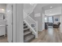 Bright entryway with staircase, wood floors, a modern light fixture, and access to the living room at 10367 Andele Ave, Las Vegas, NV 89166