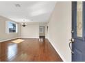 Spacious living room boasts gleaming hardwood floors, neutral paint, plantation shutters, and ample natural light at 1307 Summer Dawn Ave, Henderson, NV 89014