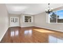 Bright living room with hardwood floors, plantation shutters, and double doors leading to another living space at 1307 Summer Dawn Ave, Henderson, NV 89014