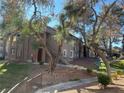 Exterior view of a two story apartment building with mature trees and landscaping at 2750 S Durango Dr # 2027, Las Vegas, NV 89117