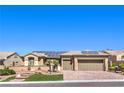 Inviting single-story home featuring lush landscaping, pavers driveway and solar panels at 2776 White Sage Dr, Henderson, NV 89052
