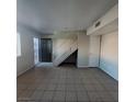 Bright living room features tile floors, staircase, and neutral paint at 3417 Civic Center Dr # B, North Las Vegas, NV 89030