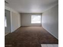 Spacious living room featuring neutral-toned walls, plush carpet, and natural light from the window at 3523 Mercury St # A, North Las Vegas, NV 89030
