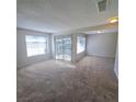 Bright and airy living room with neutral carpet, with sliding door and two windows at 3523 Mercury St # G, North Las Vegas, NV 89030