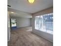 Spacious living room filled with natural light from a large window, featuring neutral walls and carpet at 3523 Mercury St # G, North Las Vegas, NV 89030
