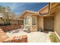 A covered front porch with a bench and a tile-roofed overhang provides shade to the entrance at 388 Coronado Dr, Henderson, NV 89015