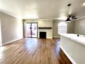 Spacious living room with hardwood floors, a fireplace, sliding glass door to the outside, and a ceiling fan at 4050 Pacific Harbors Dr # 209, Las Vegas, NV 89121