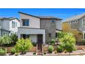 Contemporary two-story home featuring desert landscaping, dark trim, and a welcoming entryway at 410 Gracious Way, Henderson, NV 89011