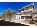 Modern two-story home with multiple balconies, a two-car garage, and desert landscaping at 505 Dragon Gate Ct, Henderson, NV 89012