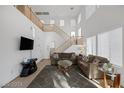 Bright living room with high ceilings, large windows, and modern staircase at 5081 Pine Mountain Ave, Las Vegas, NV 89139