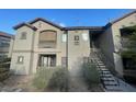 An exterior view of a two-story apartment building featuring stair access to the upper level at 8250 N Grand Canyon Dr # 2085, Las Vegas, NV 89166