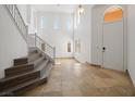 Bright foyer featuring tile flooring, high ceilings, staircase, and white front door at 8348 Nelson Ridge Ln, Las Vegas, NV 89178