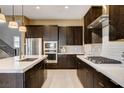 Modern kitchen features stainless steel appliances, dark wood cabinets, and white countertops at 10172 Bismarck Palms Ave, Las Vegas, NV 89166