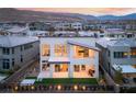 Aerial view of a modern backyard, featuring a covered patio and lush lawn, with mountain views at 10655 Patina Hills Ct, Las Vegas, NV 89135