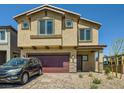 Two-story home featuring a red two-car garage and desert landscaping at 10748 Wild Poppy Ave, Las Vegas, NV 89129