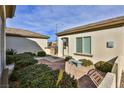 Exterior courtyard with mature landscaping and a charming stone bench at 2229 Suffron Hills Ct, Henderson, NV 89044