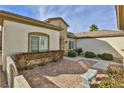 Exterior patio featuring decorative brick pavers, mature shrubs, and a small stone bench at 2229 Suffron Hills Ct, Henderson, NV 89044