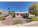 Desert landscaping of this one story home includes a large tree and multiple palm trees at 2739 Darby Falls Dr, Las Vegas, NV 89134