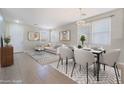 Bright living room with neutral decor, a dining table, and large windows offering ample natural light at 3517 Colby Creek Ave, North Las Vegas, NV 89081