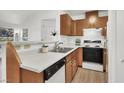 Kitchen features a dual basin sink, white countertop, and wood cabinets with black and white appliances at 3609 Melonies Dr # 93, Las Vegas, NV 89103