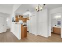 Open living space with wood floors, white walls, wood cabinets and breakfast bar looking into a small kitchen at 3609 Melonies Dr # 93, Las Vegas, NV 89103