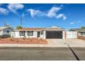 Charming single-story home with a well-manicured yard and black garage door at 5200 Longridge Ave, Las Vegas, NV 89146