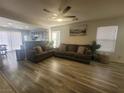 Inviting living room featuring stylish sofas, modern ceiling fan, and an abundance of natural light at 5404 Walcott Dr, Las Vegas, NV 89118