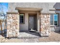 Inviting front entrance featuring stone pillars and a neutral-colored door, creating a warm and stylish welcome at 5609 Steampunk St, Las Vegas, NV 89118