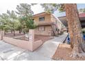 Exterior view of the apartment building featuring a tidy sidewalk, stairway, and mature trees at 605 S Royal Crest Cir # 20, Las Vegas, NV 89169