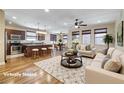 Bright and airy living room and kitchen area with hardwood floors and modern furnishings at 677 Viale Machiavelli Ln, Henderson, NV 89011