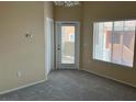 Neutral-toned room featuring plush carpeting, natural light, and a door to the outside at 9303 Gilcrease Ave # 2164, Las Vegas, NV 89149